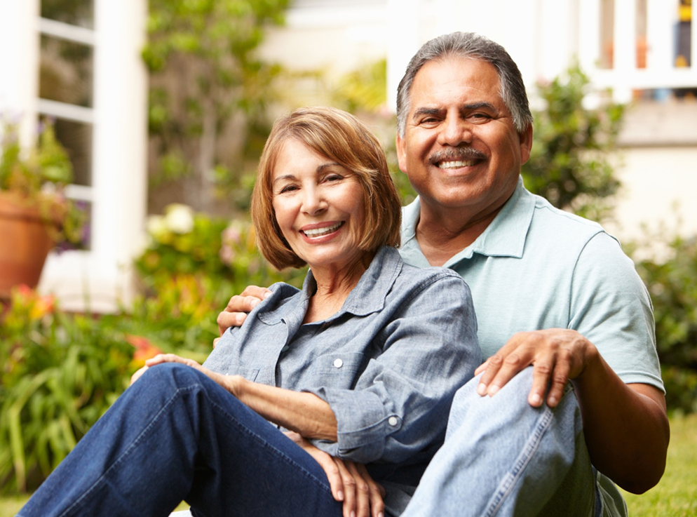 Adults sitting together on front lawn of house