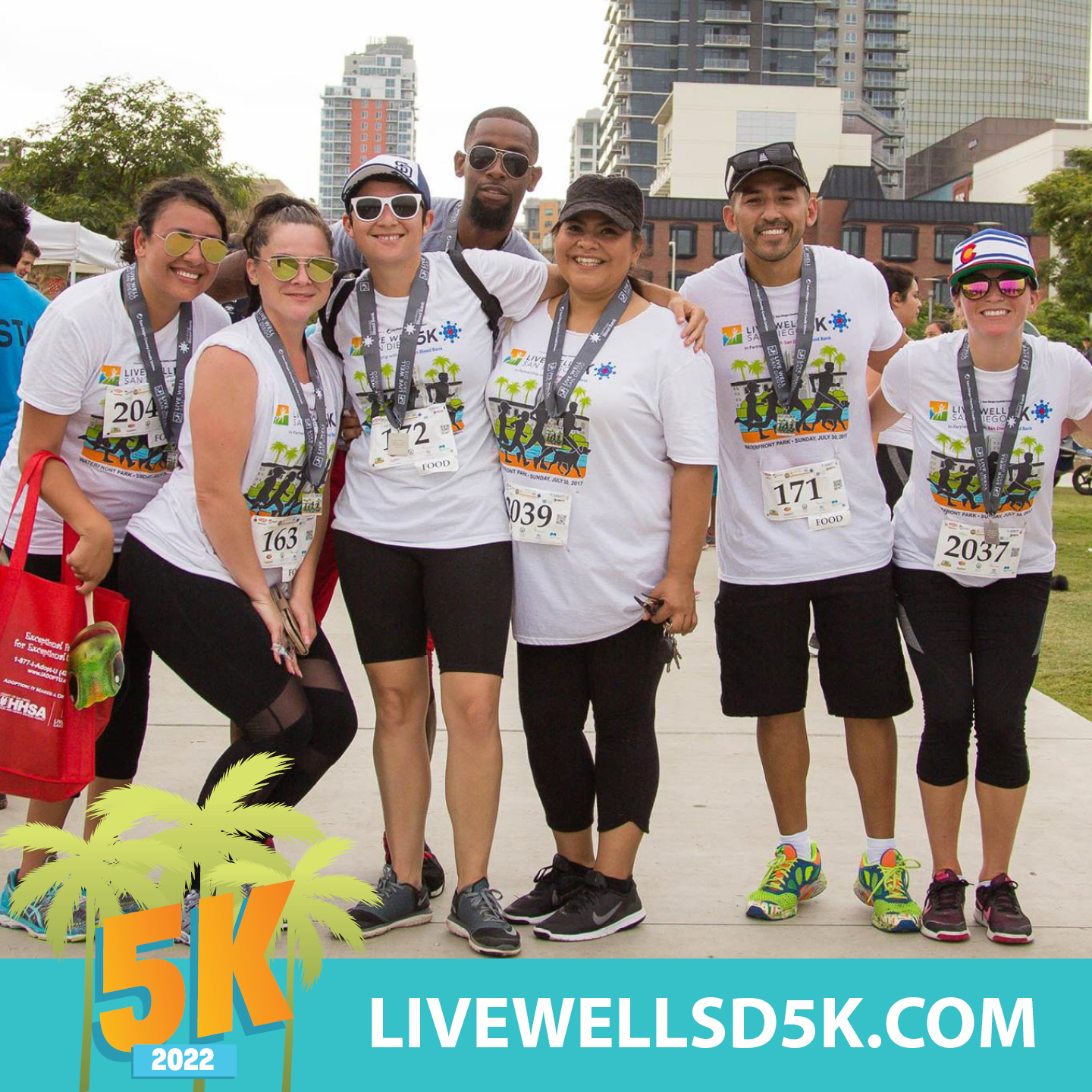 group of seven friends with 5K t-shirts and medals