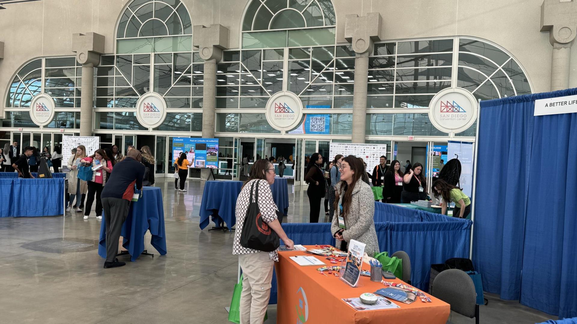 Participants Gathering Around Exhibitor Booth at the Live Well Advance