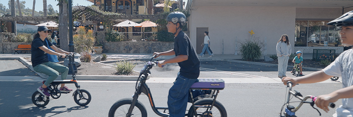 Side shot of child riding bike with proper safety equipment