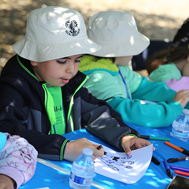 child drawing outdoors with Healing through Nature program