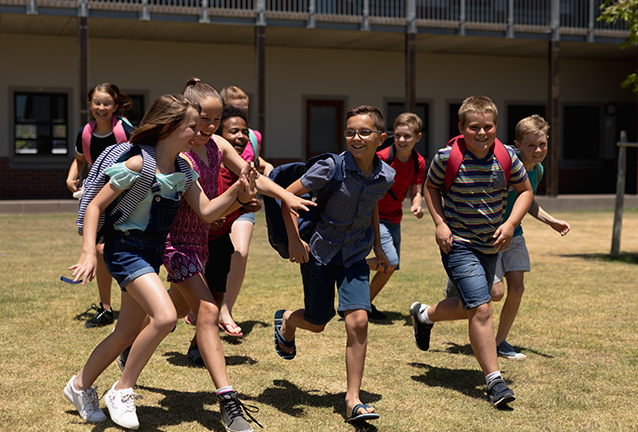 School children running on grass