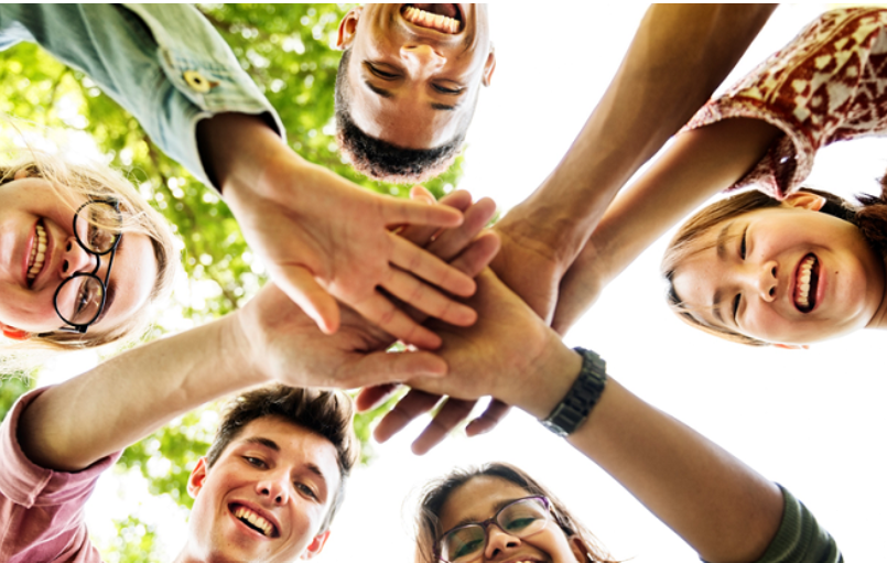 teens in circle with hands in center
